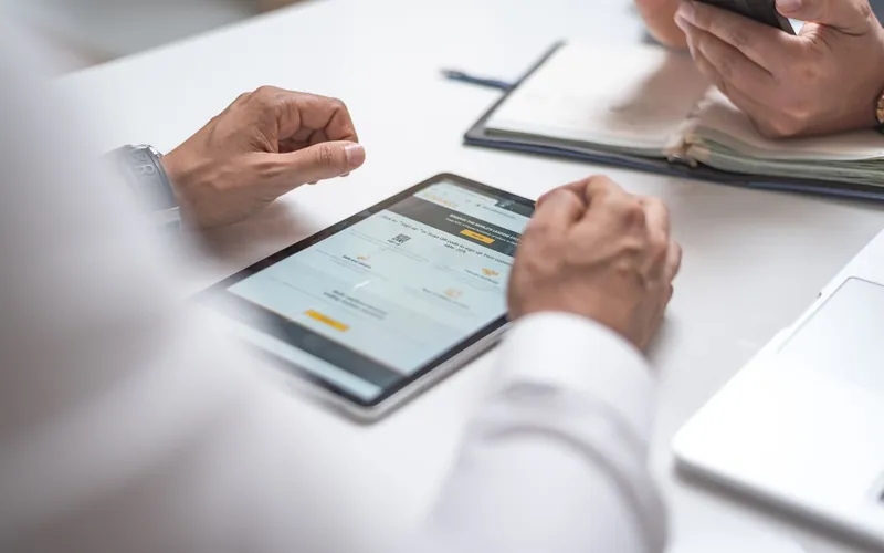 Réunion de travail autour d'une tablette et de documents